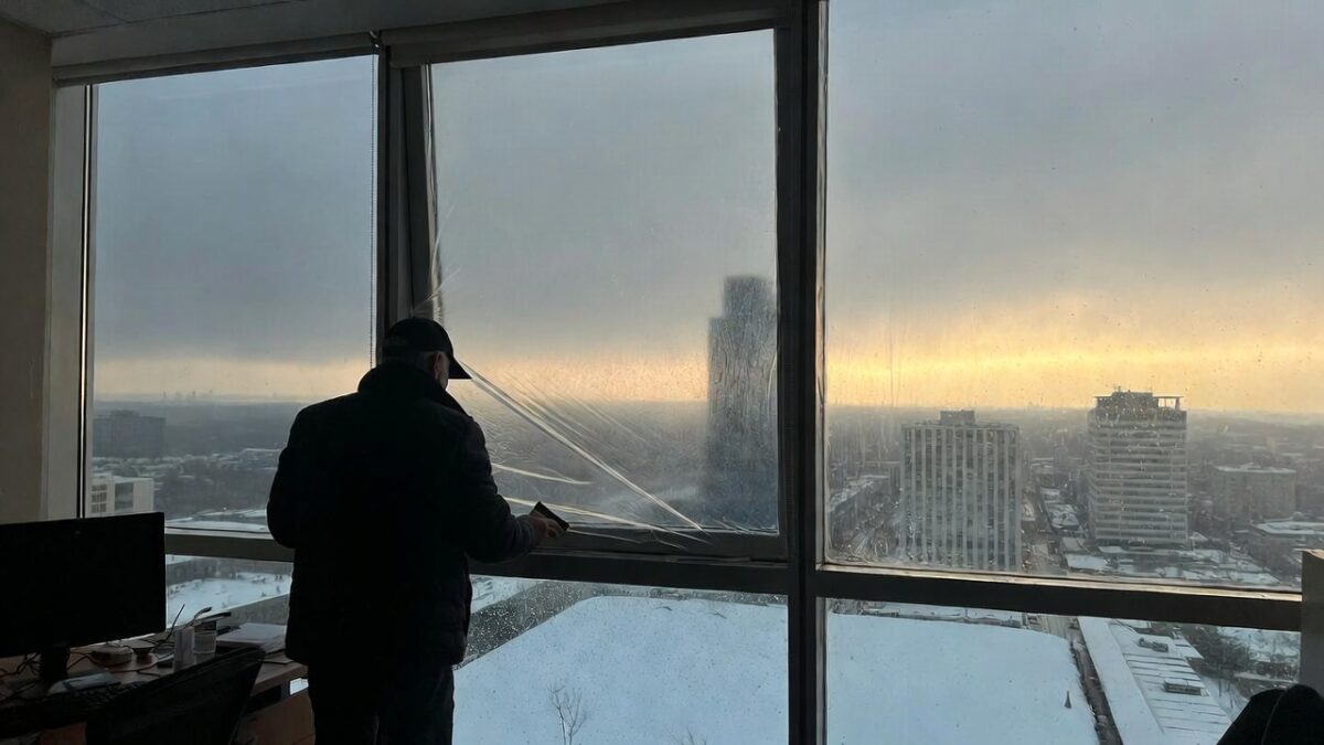 person installing window film in the winter
