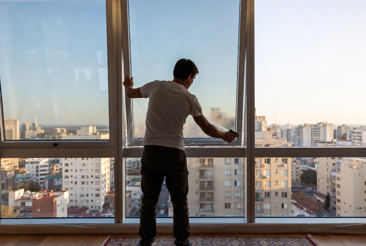 person-installing-window-film-on-glass